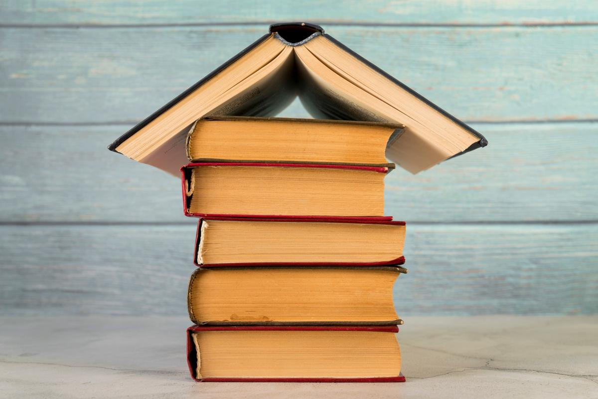 house-structure-made-with-vintage-books-against-wo