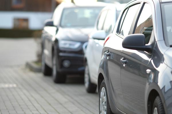 closeup-shot-black-car-parking-lot-with-blurred-ba