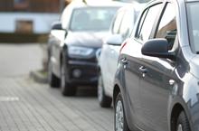 closeup-shot-black-car-parking-lot-with-blurred-ba